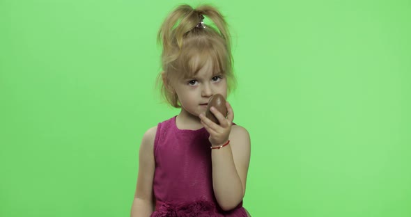 Girl in Purple Dress with Chocolate Egg. Happy Four Years Old Child. Chroma Key