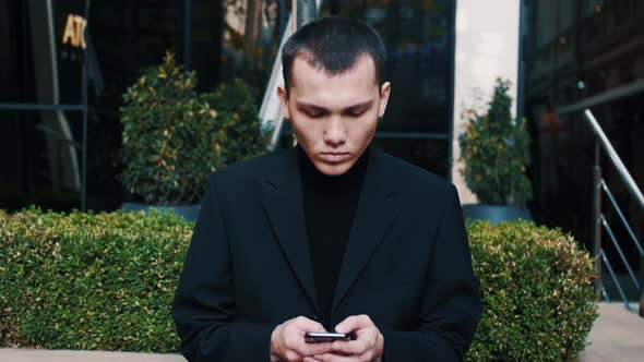 Serious Modern Startup Businessmen Receiving Bad News on His Mobile Phone While Texting Outside an