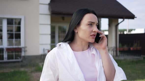 Worried Troubled Caucasian Businesswoman Talking on Phone Standing on Backyard Outdoors