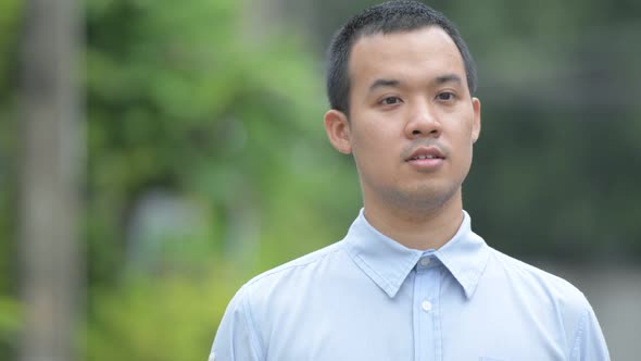 Face of Happy Asian Businessman Thinking Outdoors