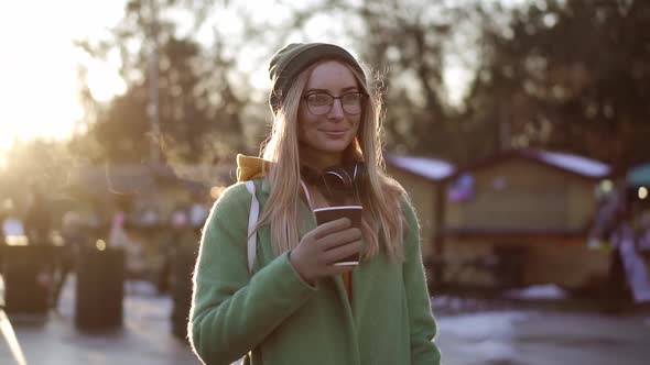 Woman Walking with Hot Drink By Winter City Park