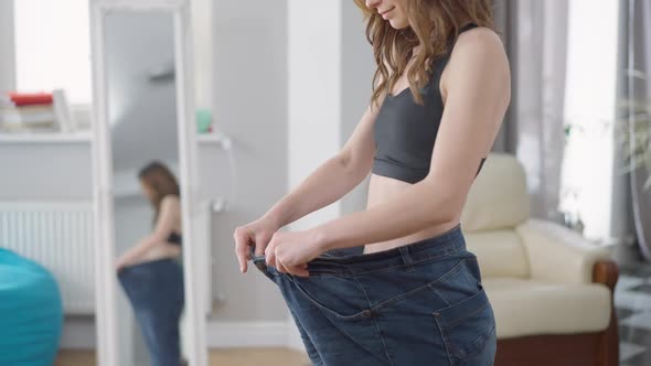 Unrecognizable Slim Young Woman in Oversize Jeans Showing Thumb Up Smiling