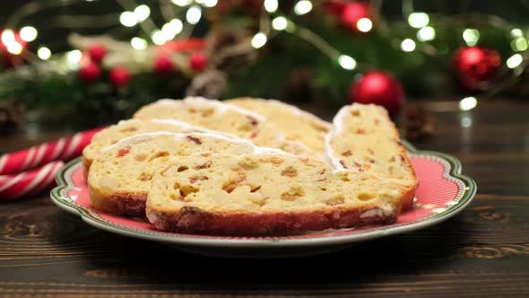 Sliced Traditional Christmas Stollen Cake with Marzipan and New Year Decorations on Wooden