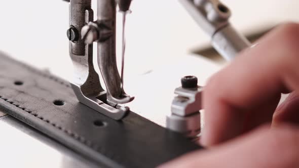 The Craftsman Stitches a Men's Leather Belt on a Sewing Machine