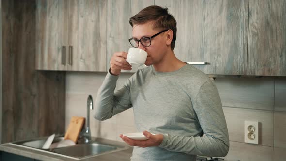 Man Is Drinking Hot Strong Coffee From a White Cup While Take a Break From Work.