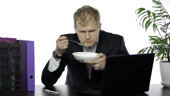 Disheveled Businessman Working in Office Having a Lunch at the Office Desk