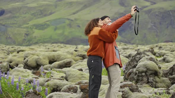 Loving Couple Posing For Selfie In Mossy Landscape