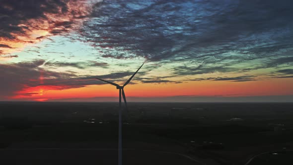 Wind turbines at dusk on green field, aerial view in Poland