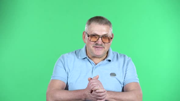 Portrait of Aged Man Friendly Communicates with Someone, Isolated Over Green Background