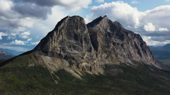 Flying Around Majestic Sukakpak Mountain against white clouds in summer Alaska