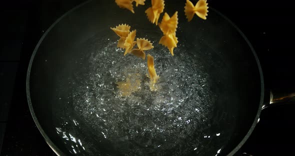 Pasta falling into boiling water, Slow motion 4K
