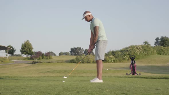 Handsome Middle Eastern Man Hitting Golf Ball on Beautiful Course