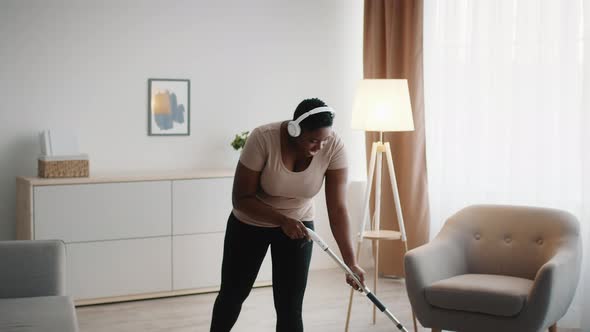 Black Lady Cleaning House Mopping Floor Wearing Headphones Indoor