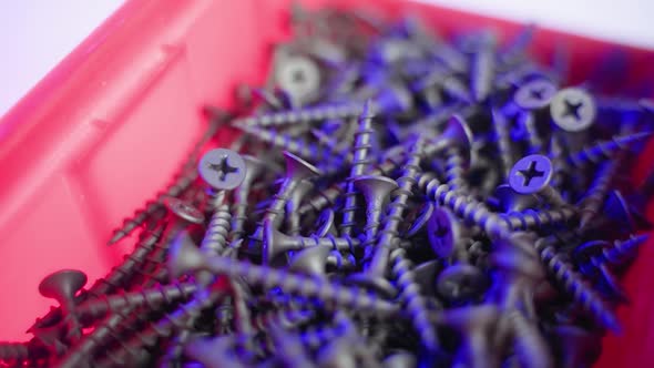 Black Short Selftapping Screws in a Red Plastic Container Spinning Closeup