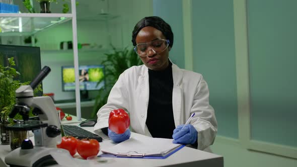 Chemist Holding Pepper Injecting with Pesticides Writing Pharmaceutical Medical Expertise alt