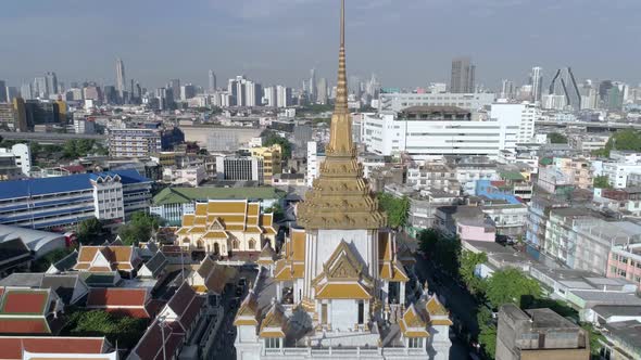 Slow crane shot of Wat Traimit and the skyline of Bangkok, Thailand