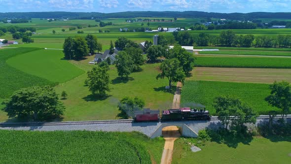 Aerial View of an Antique Steam Engine and Caboose Steaming and Puffing