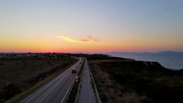 stunning aerial drone view of a road that runs along a rocky coast bathed by sea