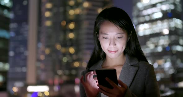 Business woman use of cellphone in city at night