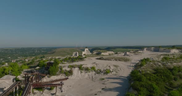 aerial shot of quarry equipment, a lonely tree on top of a cliff in quarry, fetesti, moldova