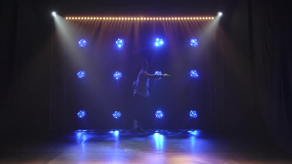 A Sensual Young Man Performs the Choreography of Modern Ballet Against the Backdrop of Blue Lights