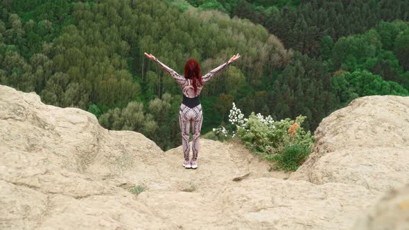 Athletic Girl Practices Yoga on Edge of a Mountain