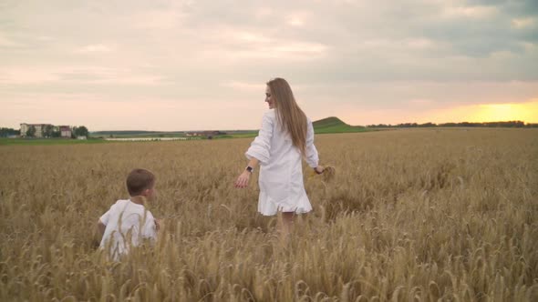 Mother Son Run Golden Wheat Field Holding Hands