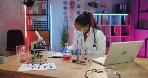 Scientist in Uniform and Gloves writing Down results of Researches Into Paper Report