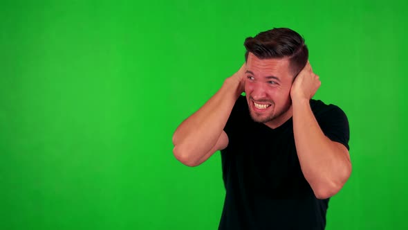 Young Handsome Caucasian Man Is Afraid (Man Covers His Ears) - Green Screen