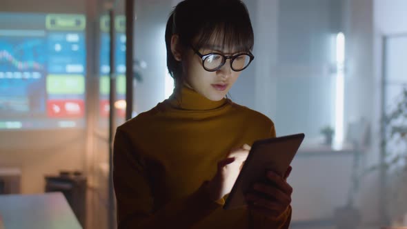 Asian Woman Using Digital Tablet in Office at Night