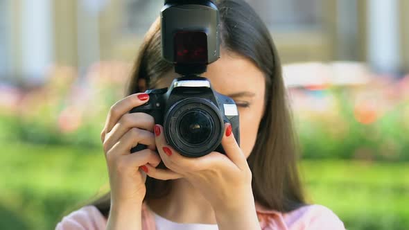 Young Woman Taking Photo by Camera and Smiling, Female Photojournalist, Blogger