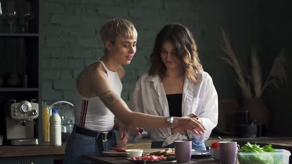 Two Young Womans Friends in Kitchen Cooking Breakfast in the Morning