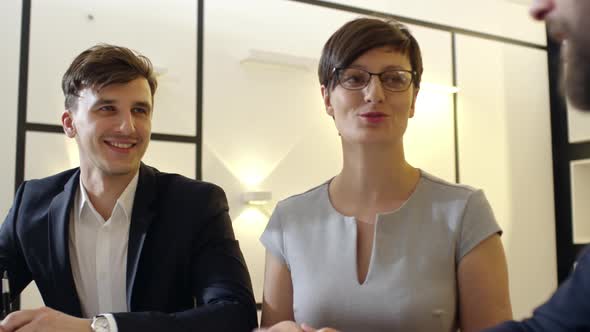 Colleagues Shaking Hands and Smiling at Discussion