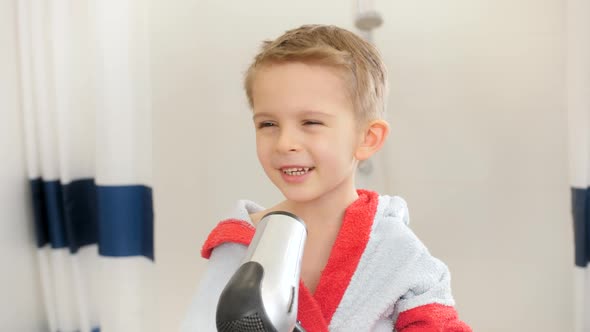 Portrait of Cute Little Boy Drying His Wet Hair with Hairdryer After Taking Bath