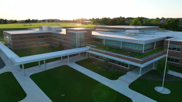 Orbiting drone view of brand new elementary school in America. Beautiful sunset over environmental s