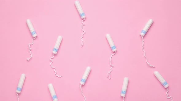 Menstrual tampons move on a pink background. Cotton tampon for women.