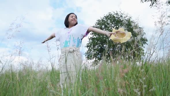 Portrait of Asian beautiful young woman freshness morning breathe deep and throw hat in nature