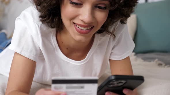 Close Up Woman Enters Credit Card Code to Pay Gifts Online Shopping Smartphone