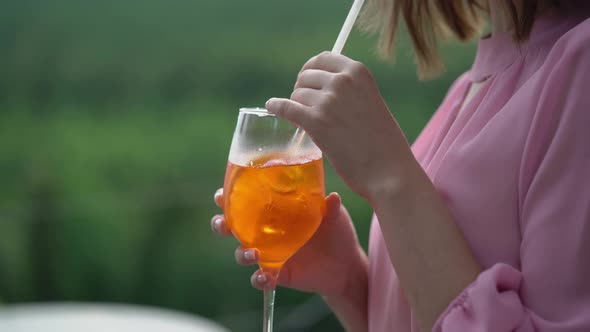 Girl with a Glass of Cocktail Aperol Spritz and Dances Outdoors