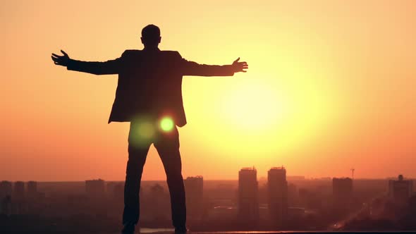 Male Celebrating Success at Sunrise in Town