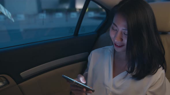 young Asia businesswoman working late talking smart phone in sitting modern city in night.