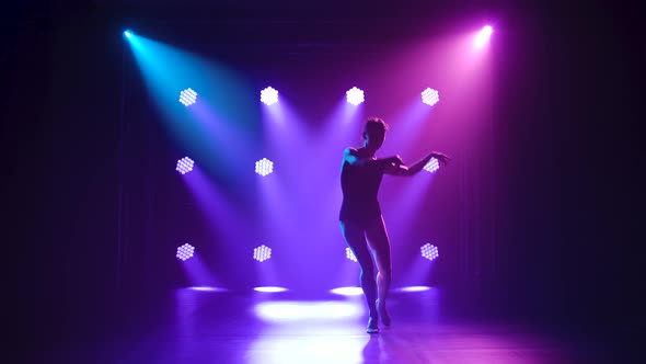 Professional Ballerina in Black Bodysuit Gracefully Dancing Ballet in Dynamic Spotlights and Smoke