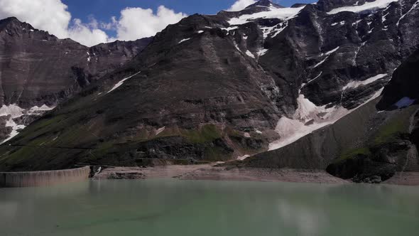 Calm Waters Of Waterfallboden Reservoir On Foothill Of Mountain In Kaprun, Austria. - aerial