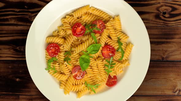 Pasta on the Plate Rotates on Wooden Rustic Background