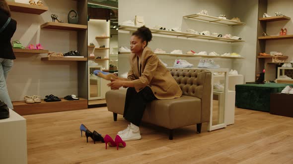 AfricanAmerican Woman in a Stylish Jacket is Sitting in a Shoe Store