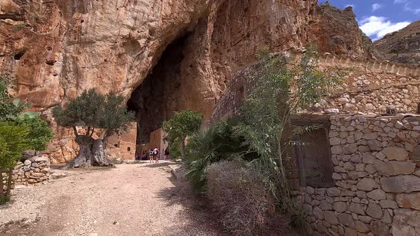 First-person view walking toward entrance of Grotta Mangiapane or Scurati Caves in Sicily, Italy. Sl