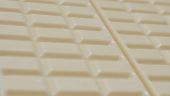 White milk chocolate blocks in the row slow tilt 4K 2160p 30fps UltraHD video - Tilting over shiny w