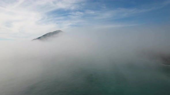 AERIAL: An Oregon mountain is revealed as a drone ascending through a wall of fog.