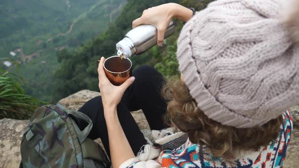Hiker Sport Woman Sitting On Mountain Peak And Pouring Hot Tea