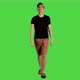 A young man smiling and looking around while walking over a green screen, 4k. - VideoHive Item for Sale